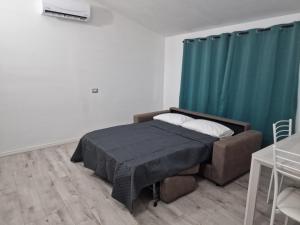a bedroom with a bed and a green curtain at Il Mirto, Residenza Privata in Bacu Abis +5 photos