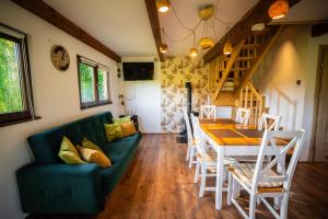 a living room with a green couch and a table at Domek Umilenia in Mrzygłód +18 photos