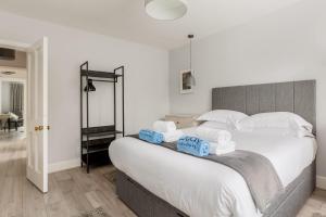 a bedroom with a large bed with towels on it at Middle Chine - Beautiful Garden and Spacious Living Space in Bournemouth