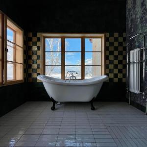a bath tub in a room with a window at Der Schwan - Gutshaus Bückling in Rambin