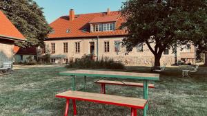 a picnic table and benches in front of a house at Der Schwan - Gutshaus Bückling in Rambin +7 photos