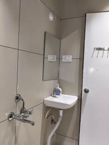 a bathroom with a sink and a mirror at Hotel Atithi Lodging Pune in Pune