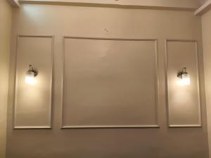 two mirrors on a wall with lights on it at Hotel Atithi Lodging Pune in Pune