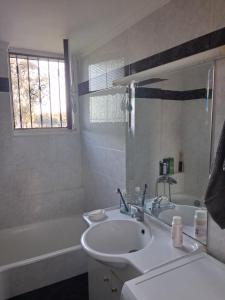 a white bathroom with a sink and a bath tub at tragano in Traganón