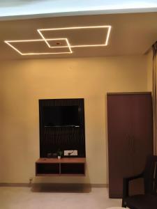 a living room with a flat screen tv on a wall at Hotel Atithi Lodging Pune in Pune