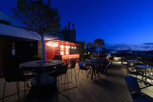 a rooftop patio with tables and chairs at night at The Corner Hotel in Barcelona