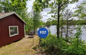a fox sign in front of a house next to a lake at Långasjönäs Camping & Stugby in Karlshamn +8 photos