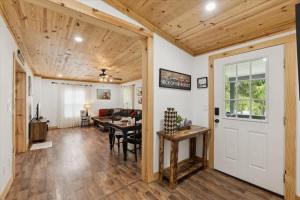 a living room with a wooden ceiling and a white door at Creekside Retreat by Beyond Expectations in Pigeon Forge
