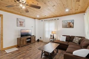 a living room with a couch and a flat screen tv at Creekside Retreat by Beyond Expectations in Pigeon Forge