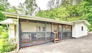 a house with a screened in porch on a driveway at Creekside Retreat by Beyond Expectations in Pigeon Forge