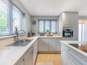 a kitchen with white cabinets and a sink at The Retreat - Uk45099 in Kirklington