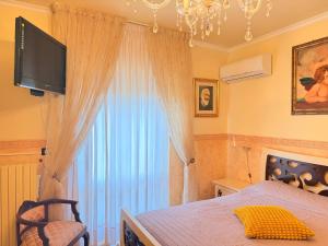a bedroom with a bed with a tv and a window at Art & Relax House in Gallipoli