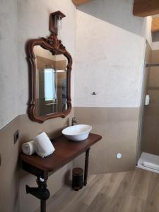 a bathroom with a sink and a mirror on a table at Monforte Country House in Monforte dʼAlba