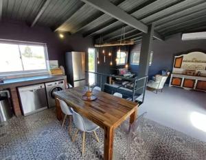 a kitchen with a wooden table and some chairs at Luxurious and spacious 2 level apartment in Tygerberg Hills +9 photos