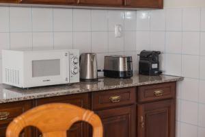 a kitchen counter with a microwave and a coffee maker at Northern Breeze Comfort in Ribeira Grande