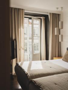 a bedroom with a bed and a large window at Casa Solayme Garrett in Lisbon