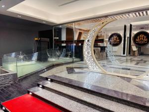 a lobby with a staircase and a red carpet at Grand Khalifa Hotel Hamama in Sylhet