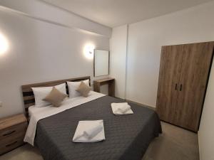 a bedroom with a bed with two white towels on it at Villa Oxana in Limenas