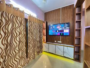 a living room with a tv and a room with a room at Richards Shared Apartment-AC in Thiruvalla