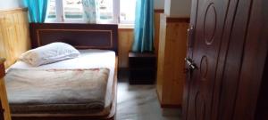 a small bedroom with a bed and a window at Aashirwad homestay in Aritar