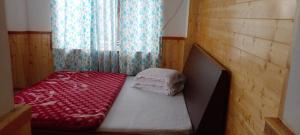a small bed in a room with a window at Aashirwad homestay in Aritar