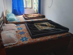 two beds with blankets on top of them in a room at Aashirwad homestay in Aritar