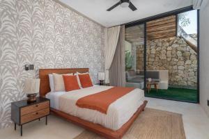 a bedroom with a bed and a stone wall at Limas in Tulum +60 photos
