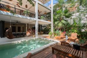 a house with a swimming pool in front of a building at Limas in Tulum