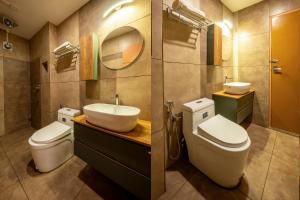 a bathroom with a sink and a toilet and a mirror at Monsoon Retreats by DAAN in Thekkady +63 photos