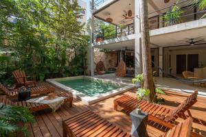 a patio with a pool and chairs and a house at Limas in Tulum