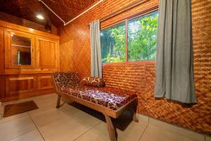 a room with a bench in front of a window at Monsoon Retreats by DAAN in Thekkady
