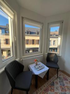 a room with two chairs and a table and two windows at Ferienwohnung Blerta in Gerolstein
