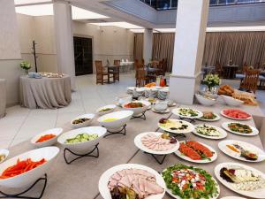 a table with many plates of food on it at 70s Guest room in Krakow