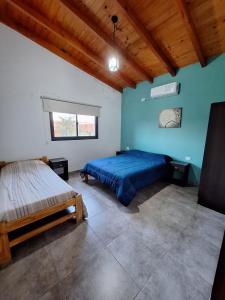 a bedroom with two beds and a blue wall at Quinta El Oasis ORO VERDE in Oro Verde +9 photos