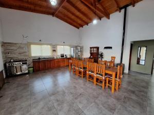 a living room with wooden chairs and a kitchen at Quinta El Oasis ORO VERDE in Oro Verde
