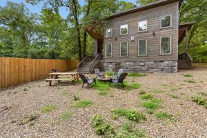 a house with a picnic table and chairs in front of it at Escape to Tranquility - Hot Tub - BBQ - Pets in Broken Bow