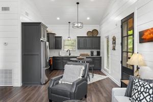 a kitchen with black and white cabinets and a table and chairs at Escape to Tranquility - Hot Tub - BBQ - Pets in Broken Bow +14 photos