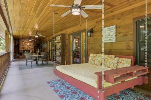 a porch with a bed swing and a table at Chasing Cubs Cabin by Beyond Expectations in Sevierville