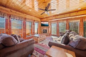 a living room with couches and a ceiling fan at Paradise Pointe Pool Lodge by Beyond Expectations in Sevierville
