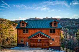 a large wooden cabin with a green roof at Paradise Pointe Pool Lodge by Beyond Expectations in Sevierville