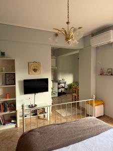 a bedroom with a bed with a television and a staircase at The Stay in Igoumenitsa
