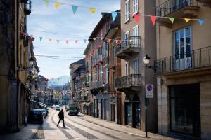 a man walking down a street with flags at CA' VARADE di Martina Scarduelli in Varallo