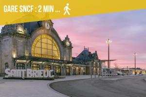 a large building with a sign in front of it at L'Entre Deux Gare Centre-Ville in Saint-Brieuc