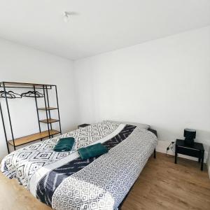a bedroom with a bed with a black and white comforter at L'Entre Deux Gare Centre-Ville in Saint-Brieuc