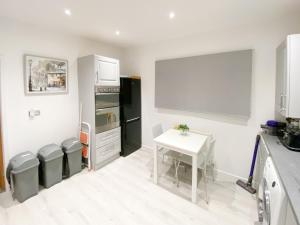 a kitchen with a table and a black refrigerator at Newcastle Lodge in Thornton