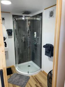 a shower in a bathroom with a glass enclosure at Mountain Top Tiny House by Beyond Expectations in Waldens Creek