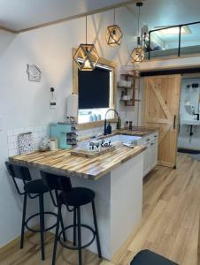 a kitchen with a large island with two bar stools at Mountain Top Tiny House by Beyond Expectations in Waldens Creek
