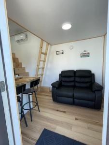a living room with a black couch and a table at Mountain Top Tiny House by Beyond Expectations in Waldens Creek