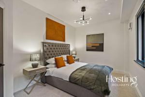 a bedroom with a bed with orange pillows at Platform One Apartments - Caversham in Reading +1 photo