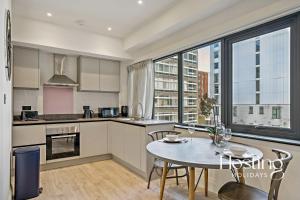 a kitchen with a table and a large window at Platform One Apartments - Caversham in Reading